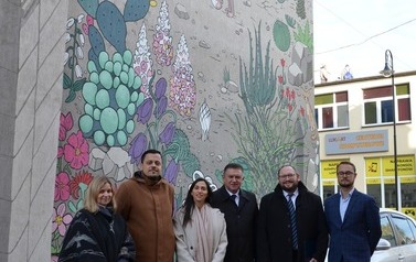 Grupowe zdjęcie na tle muralu Ben Guriona 