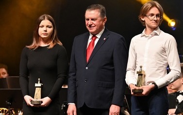 dw&oacute;ch meżczyzn i kobieta stojący na scenie