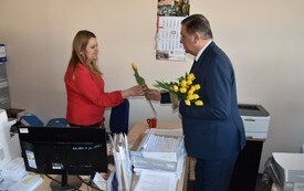 Z okazji Dnia Kobiet Burmistrz wręcza koleżance z pracy tulipana