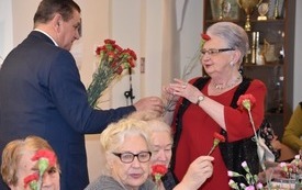 Burmistrz wręczający kwiatka Pani z Klubu Senior+  