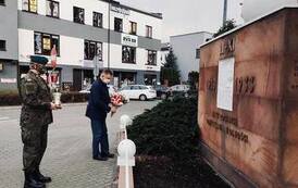 Składanie kwiat&oacute;w pod pomnikiem