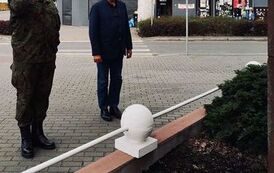 Składanie kwiat&oacute;w pod pomnikiem