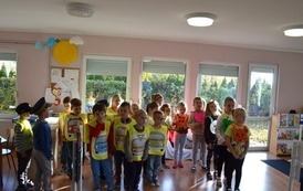 Grupa dzieci stoi w sali przedszkola