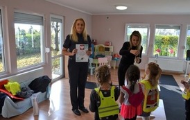Strażniczka Miejska trzyma w dłoniach dyplom otrzymany od grupy dzieci z przedszkola 