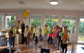 Grupa dzieci przyglądająca się chłopcu, kt&oacute;ry założył czapke Straży Miejskiej 