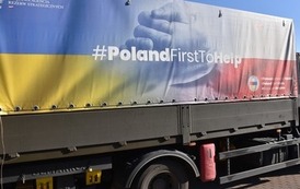 na plandece samochodu cieżarowego widać napis #PolandFirstToHelp na tle flagi Ukrainy i Polski 