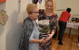 Wręczenie prezentu w ręce członka klubu seniora 
