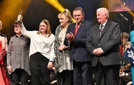 grupa osob&oacute; pozująca d ozdjęcia na scenie 