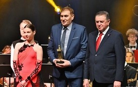 trzy osoby stojące na scenie 