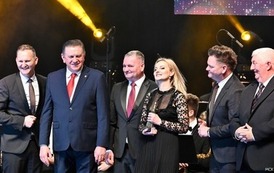 grupa os&oacute;b stoi na scenie 