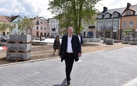 Na pierwszym planie Wiesław Raboszuk idący rynkiem Płońska 