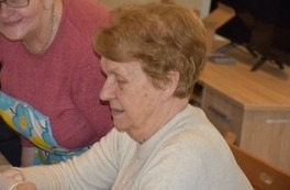 Seniorka pomaga przygotować innym wsp&oacute;lny posiłek