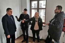 Burmistrz udziela wywiadu mediom na temat wyremontowanych kamienic
