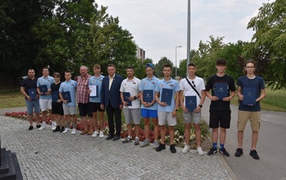 Zdjęcie do Zawodnicy z Płońskiej Akademii Futbolu wraz z trenerem z okolicznościowymi dyplomami od Andrzeja Pietrasika - Burmistrza Płońska